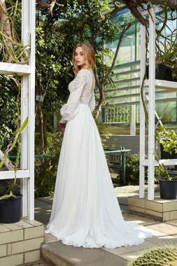 Uzun beyaz gelinlik içinde güzel bir gelin yeşil park bahçesinin arka bahçesinde büyük bir gün kutlama yapıyor. Yazın nişanlısı. Güzel bir yüz, sarı saçlı, makyajlı bir kadın..