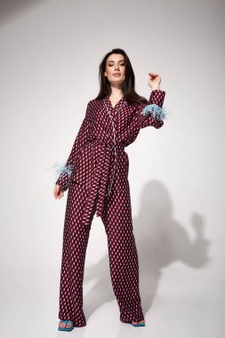 Güzel, seksi bir kadın. Yüzü doğal makyajlı, esmer, ipek kumaşlı, takım elbiseli, bluzlu, tüylü, rahat bir ev elbisesi, lüks bir pijama partisi, çekici bir manken..