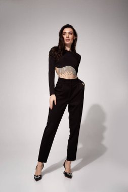 Güzel, genç, seksi iş kadını esmer, gece makyajlı, siyah takım elbiseli, ceketli, yüksek topuklu ayakkabılı, toplantı için giyinik, yürüyüş, vücut şekli mükemmel..