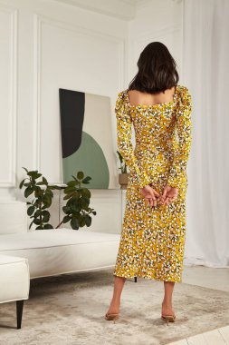Moda stili seksi güzel kadın mükemmel vücut şekli esmer esmer saç şık moda elbiseler giyip iç dekorasyon odası, otel odası romantik randevusu, parti buluşması..