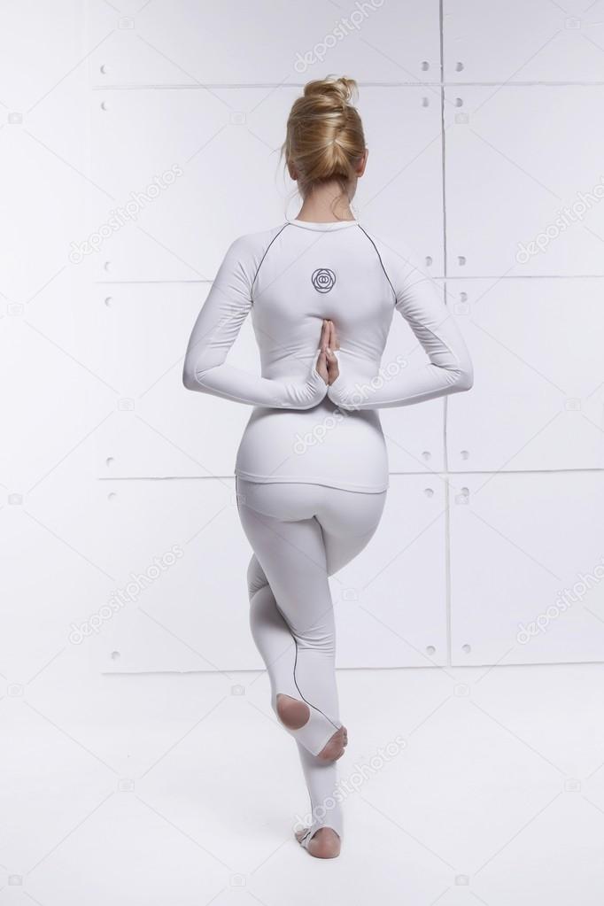 Beautiful sexy blonde with perfect athletic slim figure engaged in yoga, exercise or fitness, lead a healthy lifestyle, and eats right, dressed in comfortable casual clothes relaxes and meditation