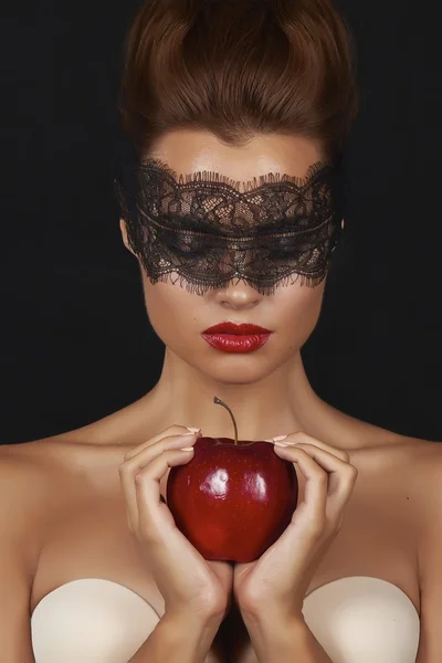 Young beautiful sexy woman with dark lace on eyes bare shoulders and neck, holding big red apple to enjoy the taste and are dieting, feeling temptation, teeth passion sex red lips — Stock Photo, Image