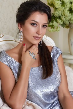 sersualnaya güzel gümüş pullu ve Küpe çiçeği ile arka koltukta oturan genç esmer bir kadın kısa bir gece elbisesi giyen damat makyaj şık akşam ile işlemeli