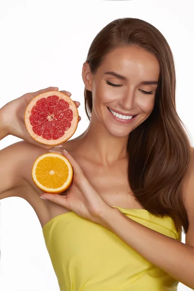 Schöne sexy junge Frau mit perfekter gesunder Haut und langen braunen Haaren Tag Make-up nackten Schultern halten Orange Zitrone Grapefruit gesunde Ernährung Bio-Lebensmittel Diät Gewichtsverlust — Stockfoto