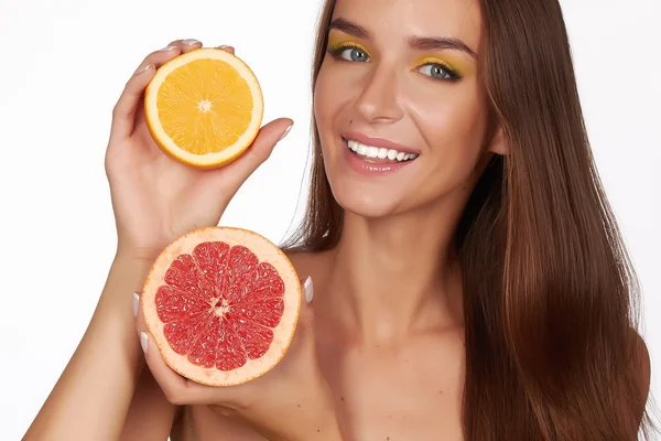 Hermosa mujer joven sexy con una piel sana perfecta y maquillaje largo cabello castaño día hombros desnudos sosteniendo naranja limón pomelo alimentación saludable dieta dieta pérdida de peso — Foto de Stock