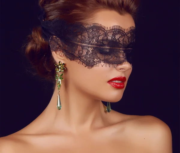 Young beautiful sexy woman with dark lace on eyes bare shoulders and neck, jewelry earrings, feeling temptation, passion sex red lips — Stock Photo, Image