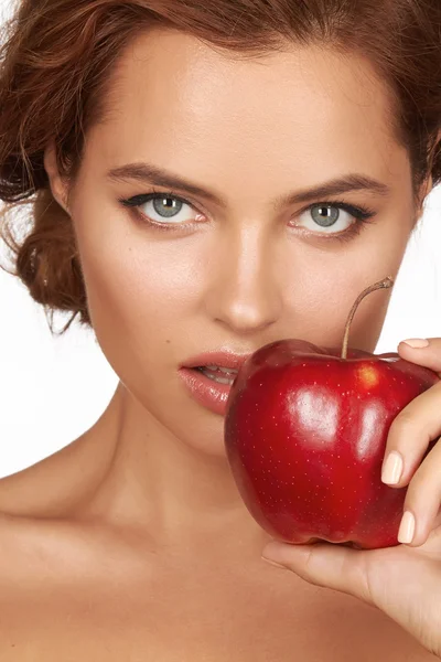 Krásná mladá sexy dívka s tmavými kudrnatými vlasy, holé ramena a krk, drží velké červené jablko vychutnat chuť a jsou diety, zdravé výživy a biopotravin, pocit pokušení, úsměv, zuby — Stock fotografie