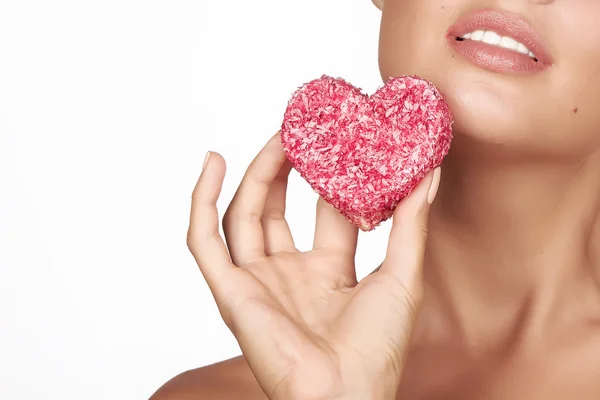 Schöne sexy brünette Frau essen Kuchen Form des Herzens auf weißem Hintergrund, gesundes Essen, lecker, organisch, romantischer Valentinstag — Stockfoto