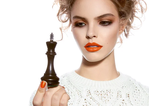 Красива жінка з вечірнім макіяжем тримає королівську шахову фігуру — стокове фото