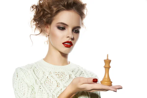 Mulher bonita com maquiagem à noite segurando uma peça de xadrez rei — Fotografia de Stock