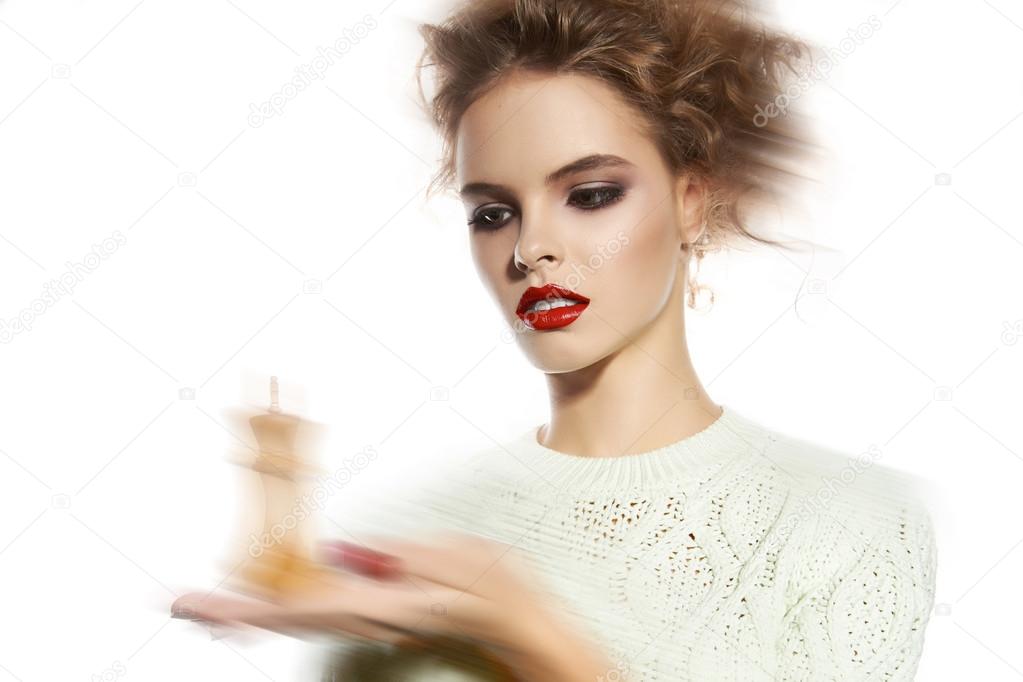 Beautiful woman with evening make-up holding a king chess piece