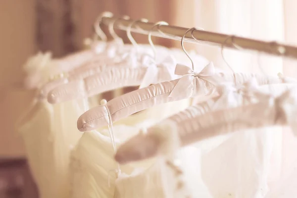 Mooie witte bruiloft jurken gemaakt van zijde op hangers — Stockfoto