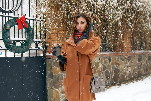 Woman with cup of coffee walk on snow street Christmas New Year — Stock Photo, Image