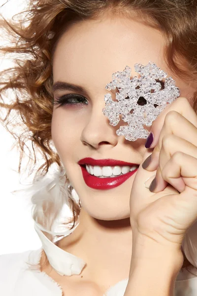 Schöne Mädchen mit Abend Make-up Lächeln nehmen kristallene Schneeflocke — Stockfoto