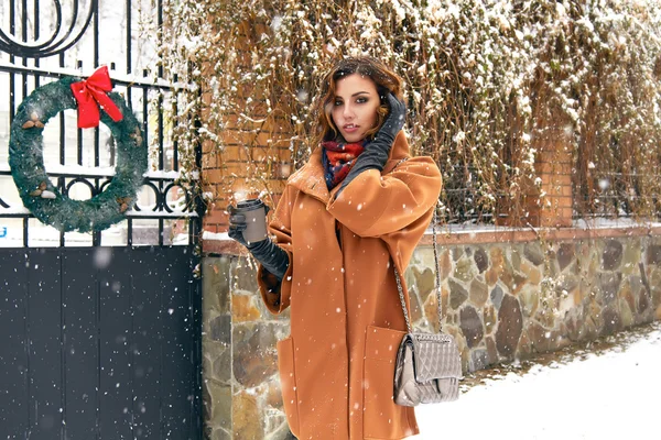 Woman with cup of coffee walk on snow street Christmas New Year — Stock Photo, Image