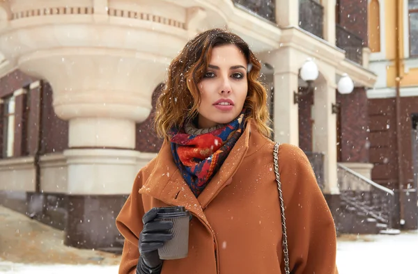 Woman with cup of coffee walk on snow street Christmas New Year — Stock Photo, Image