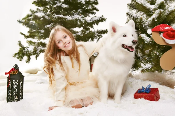 Krásná holčička, sedět ve sněhu na vánoční stromky — Stock fotografie