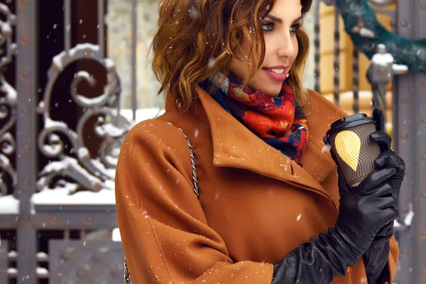 Woman with cup of coffee walk on snow street Christmas New Year — Stock Photo, Image