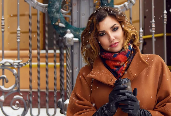 Woman with cup of coffee walk on snow street Christmas New Year — Stock Photo, Image