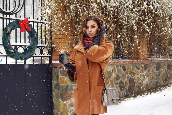 Woman with cup of coffee walk on snow street Christmas New Year — Stock Photo, Image