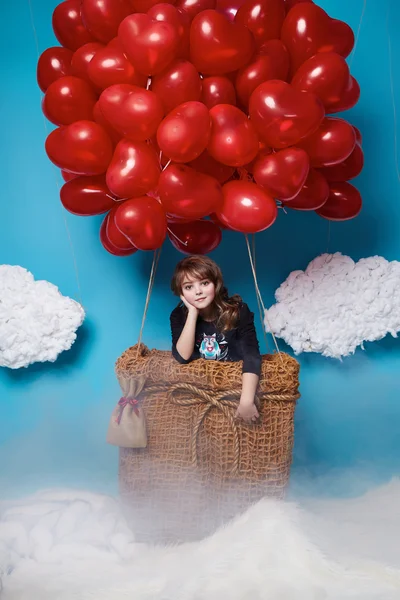 Pequeña linda chica volando en globos corazón rojo Día de San Valentín — Foto de Stock