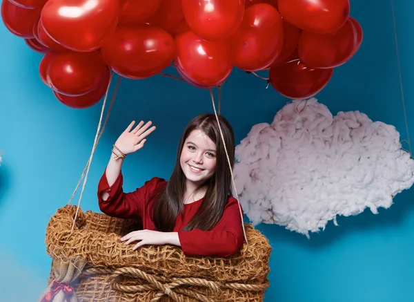 Pequeña linda chica volando en globos corazón rojo Día de San Valentín —  Fotos de Stock