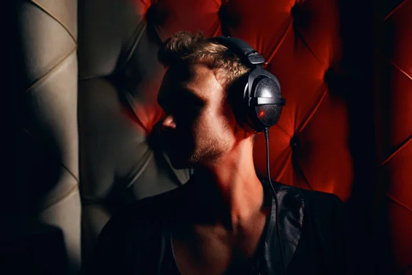 Guapo sexy hombre DJ en las sombras en los auriculares — Foto de Stock