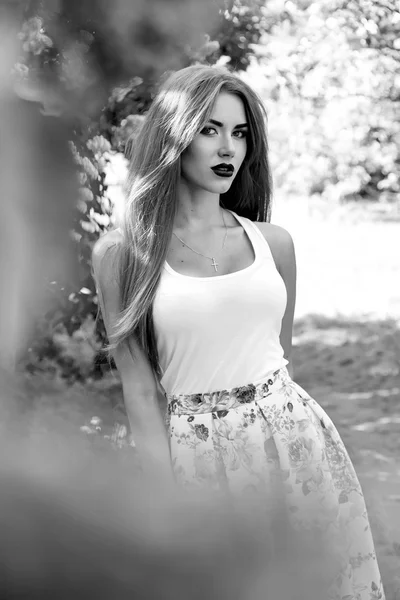 Mooie sexy vrouw brunette wandeling in park zon glans jurk — Stockfoto