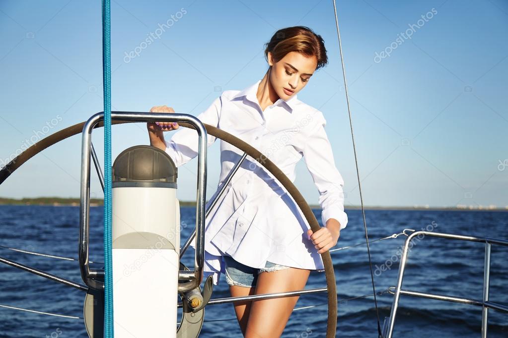 Beautiful sexy brunette girl in dress makeup summer trip yacht
