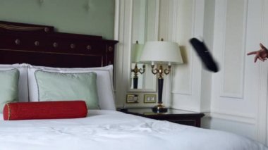 Lüks otel yatak odasında sıska kısa elbise takı güneş gözlüğü giyen güzel seksi sarışın iş kadını içki şarap toplantı dan önce dinlenmek moda trendi kırmızı ruj yastık çarşafları makyaj yapmak