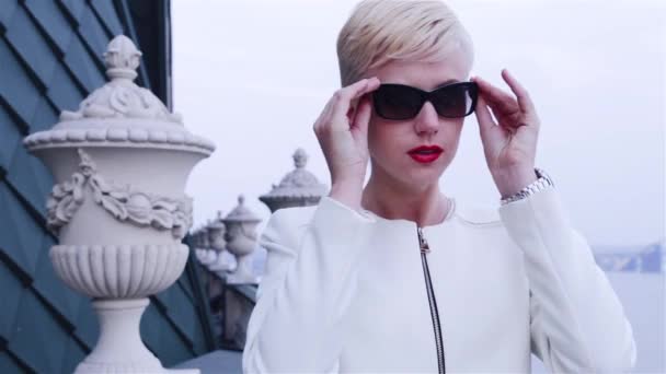 Vacker sexig blond Business kvinnor bär solglasögon vit jacka väntar möte tala telefon stadens gator — Stockvideo