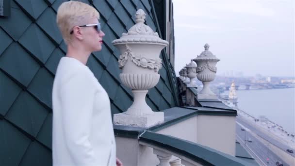 Mooie sexy blonde Business vrouwen dragen zonnebril witte jas wachten vergadering spreek telefoon stad straten — Stockvideo