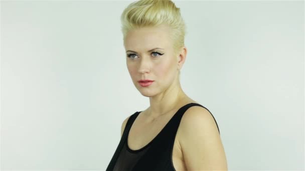 Krásná mladá blondýnka s krátkými vlasy v černých šatech s obnaženými rameny vyjadřuje pocity radosti sexy něžnosti — Stock video