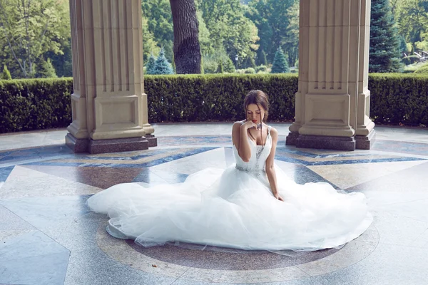 Hermosa mujer joven sexy novia morena en un vestido de novia blanco de lujo la naturaleza Castillo de la felicidad de verano espera al novio antes de la ceremonia de la boda — Foto de Stock