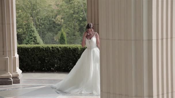 Hermosa mujer joven sexy novia morena en un vestido de novia blanco de lujo la naturaleza Castillo de la felicidad de verano espera al novio antes de la ceremonia de la boda — Vídeos de Stock