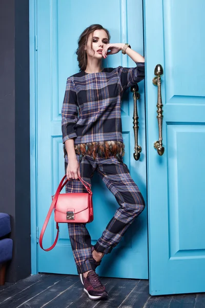 Güzel seksi kız moda giyim yeni katalog koleksiyonu, modern, şık pantolon, süslü ipek gömlek Aksesuar yüksek topuklu ayakkabılar, mavi kapı giriş çıkış ile iç odası tarzı giyinmiş
