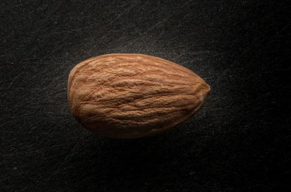 Single Whole Almond on Black Background — Stock Photo, Image