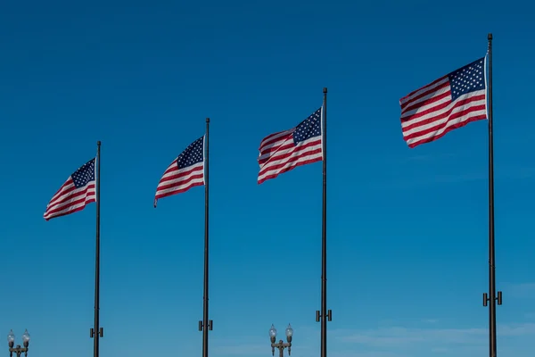 Línea de cuatro banderas americanas ondeando en el cielo azul — Foto de Stock
