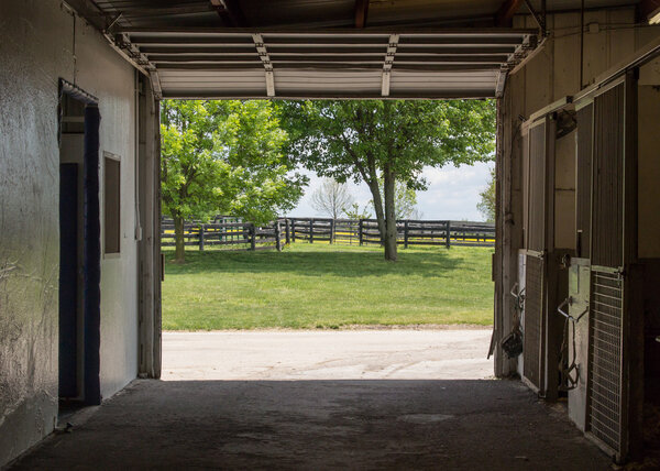 Empty Stables Leading to Horse Farm Fields