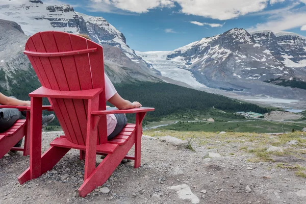 Detrás de la vista de la mujer sentada en la silla disfrutando de la vista — Foto de Stock