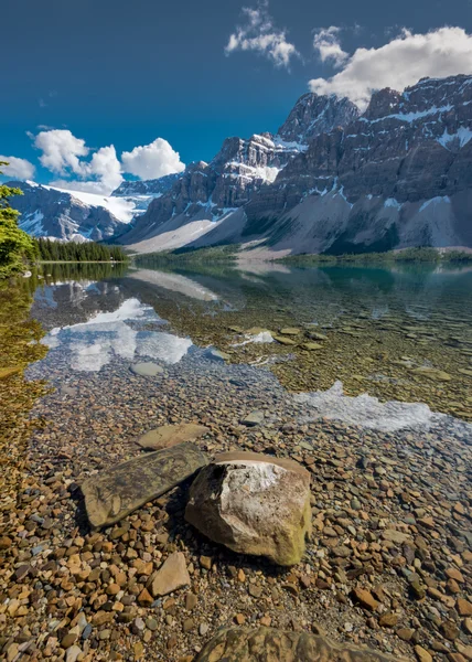 Velké skalní se tyčí nad vodou na jezero Bow — Stock fotografie