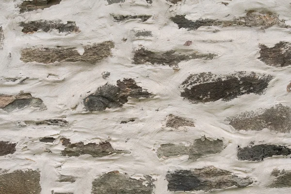Plâtre épais sur fond de mur de pierre — Photo