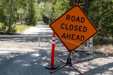 Road Closed Ahead Sign keeps people from entering campground on gravel road clipart