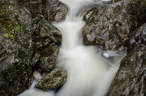 Lång exponering av vattnet rusa över stenar — Stockfoto