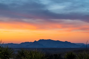 Big Bend Ulusal Parkı 'ndaki Chisos Dağları' nın üzerinde renkli bir gökyüzü