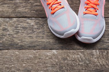 Ahşap arka planı olan spor ayakkabıları.