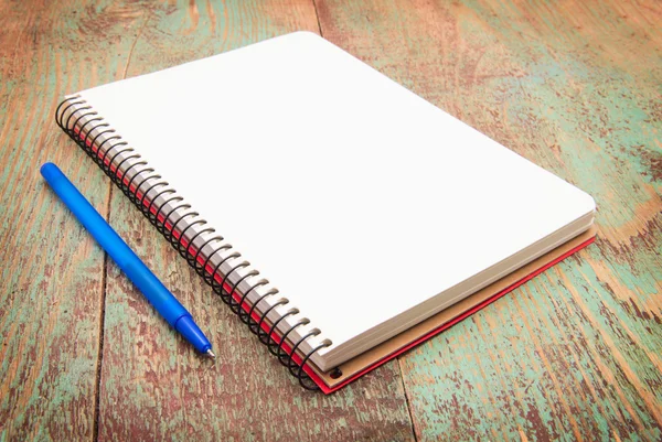 Cuaderno en espiral y pluma en escritorio de madera —  Fotos de Stock