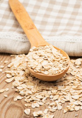 Tam buğday, yulaf ezmesi ile tahta kaşık ve saf peçete.