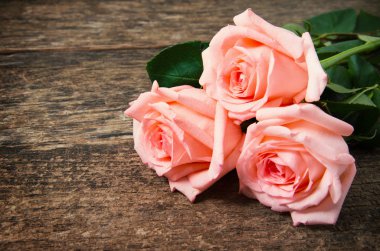 Ahşap masanın üzerinde pembe güller