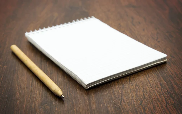 Cuaderno en espiral y pluma en escritorio de madera —  Fotos de Stock